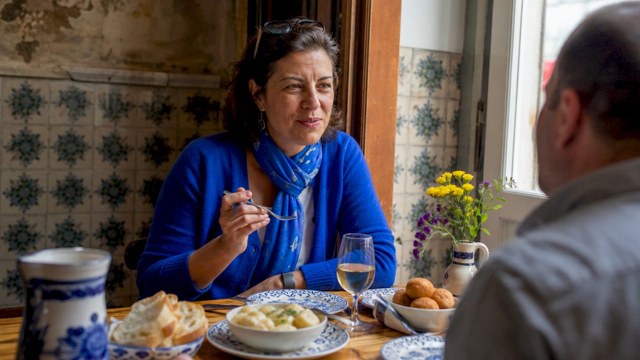 Woman enjoying petiscos dish at outdoor Lisbon tasca