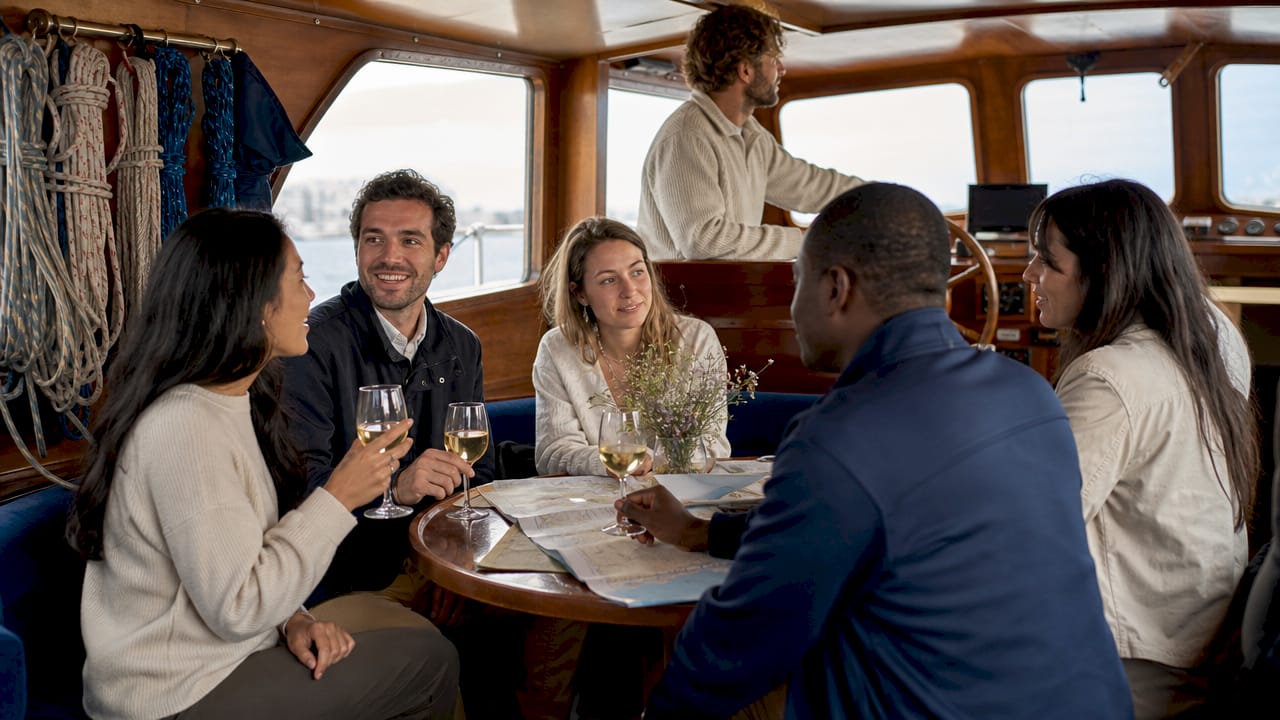 Group enjoying sailing tour inside boat cabin
