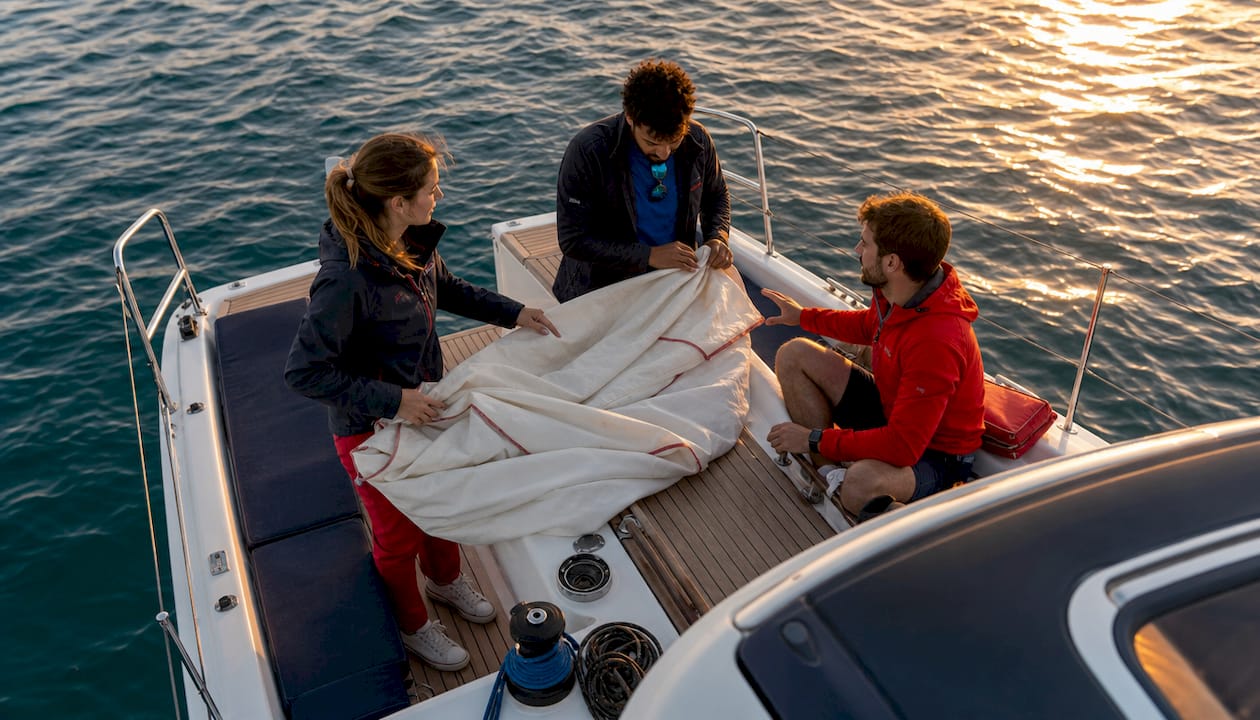 Crew coordinating sail adjustments on yacht deck