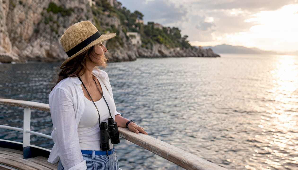 Traveler on small cruise ship looking at coast