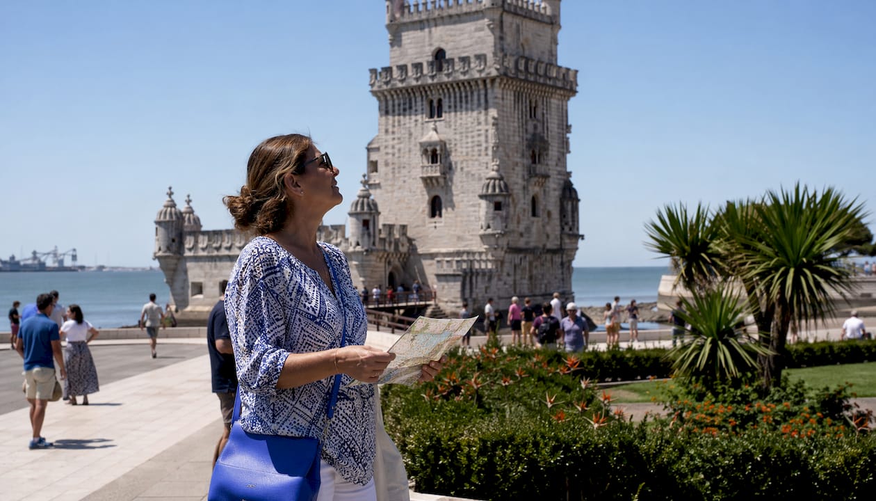 Tourist examining Belém Tower details in morning light