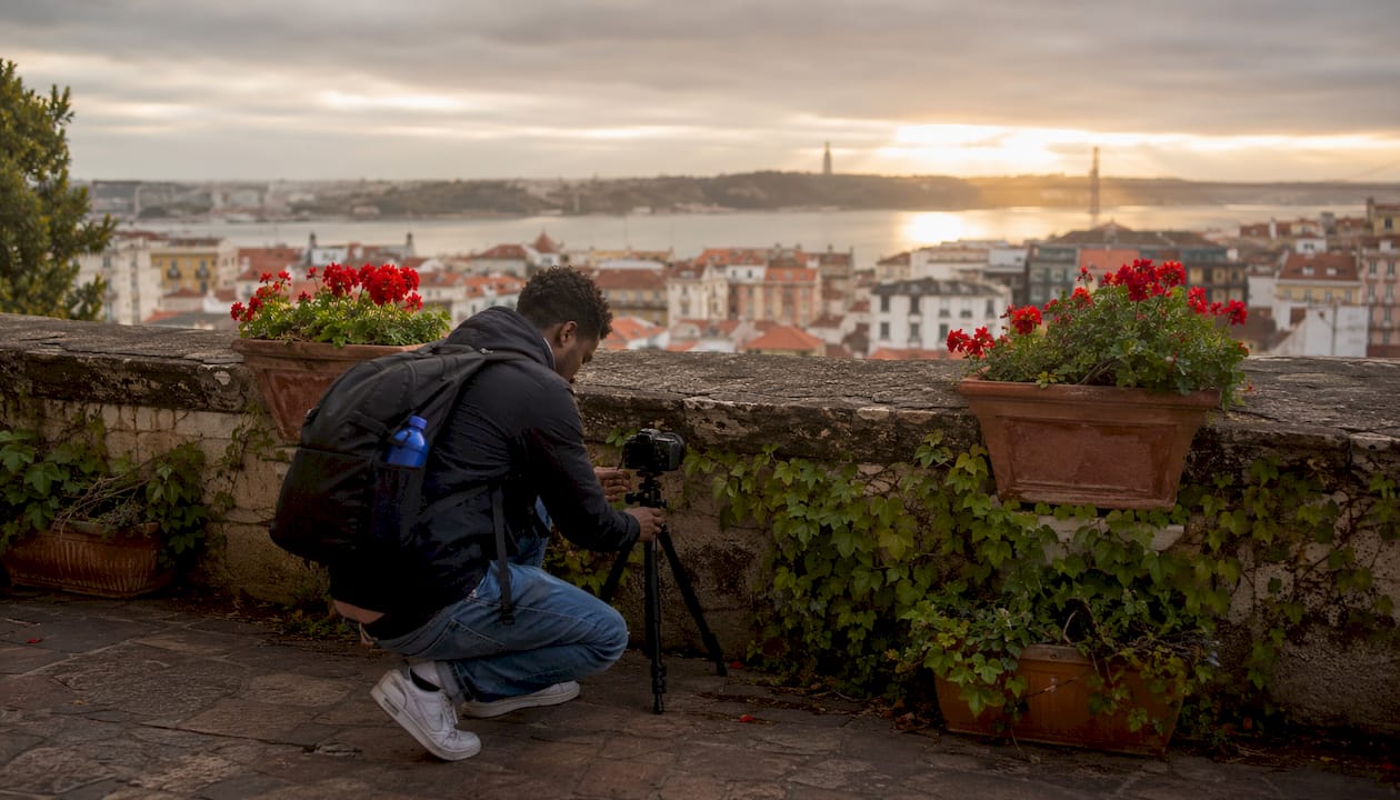 Photographer at Lisbon miradouro viewpoint at sunset