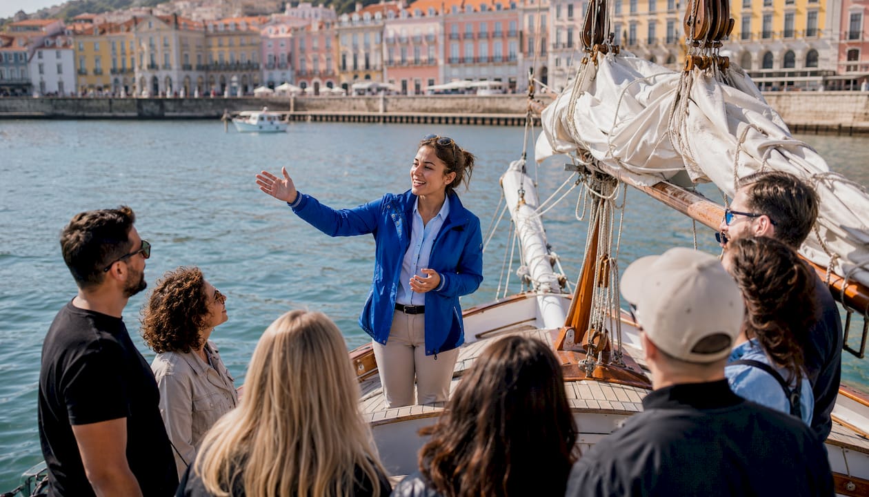 Sailing tour guide speaking to tourists on Lisbon boat