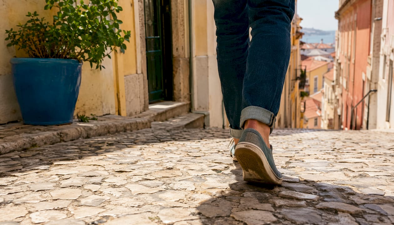 Close-up of walking shoes on Lisbon cobblestone street