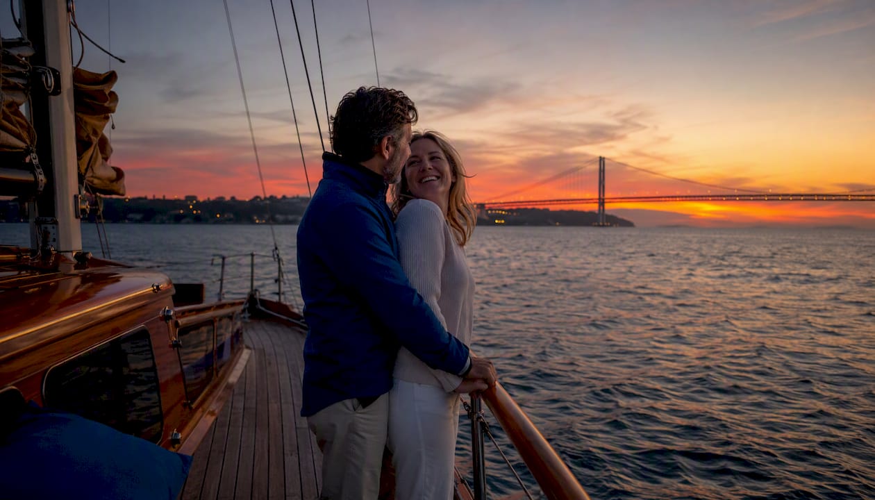 Couple watching Lisbon sunset from sailboat