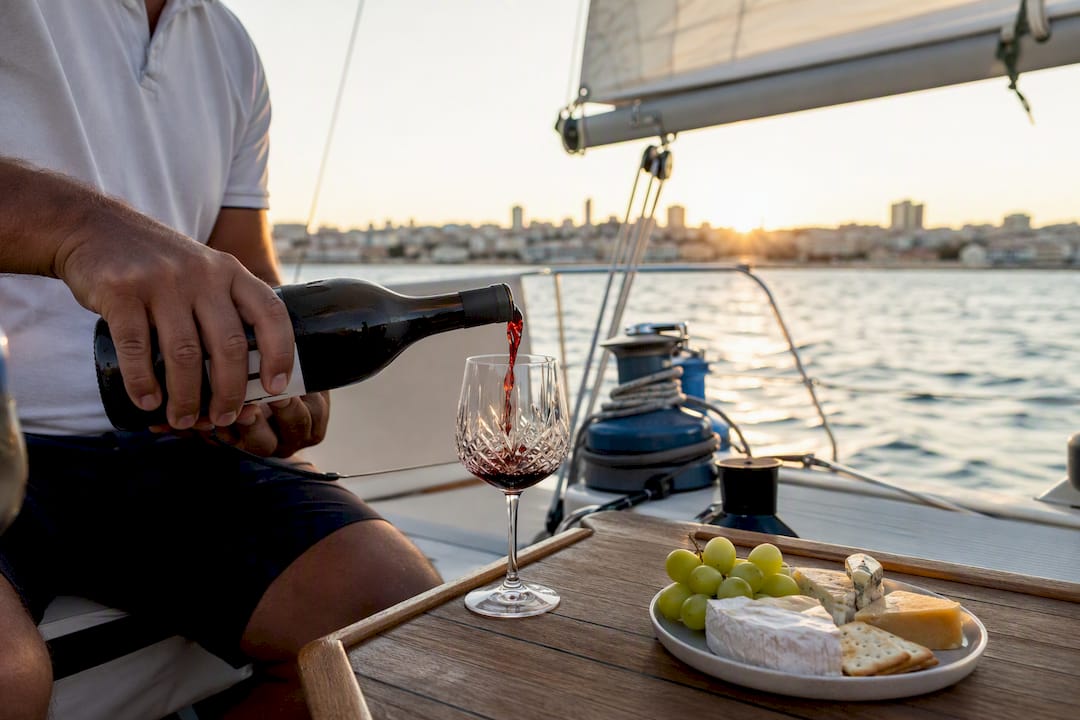 Skipper pouring wine on private sailboat