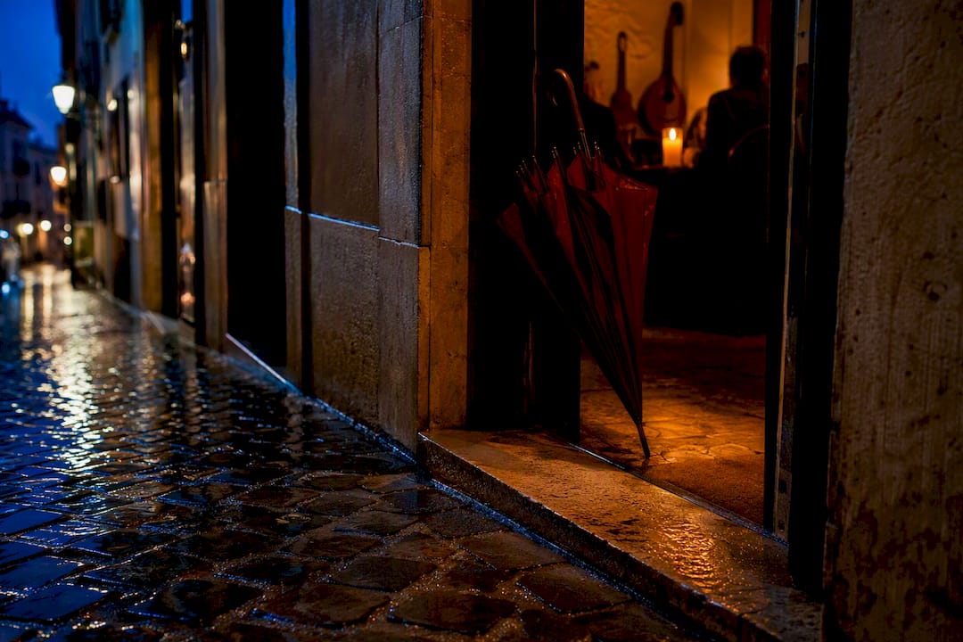 Rainy Lisbon cobblestones outside a fado venue