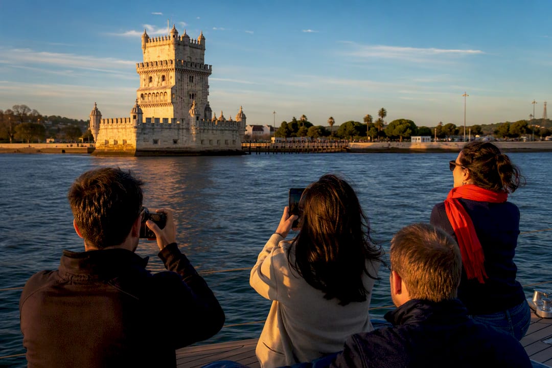Visitors photographing Lisbon landmarks from sailboat