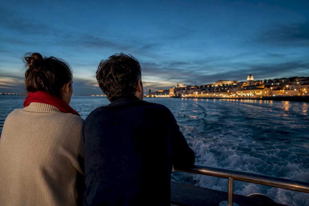 Passengers watching Lisbon lights from Tagus