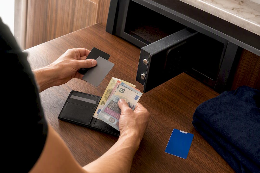 Cash and cards divided beside hotel safe