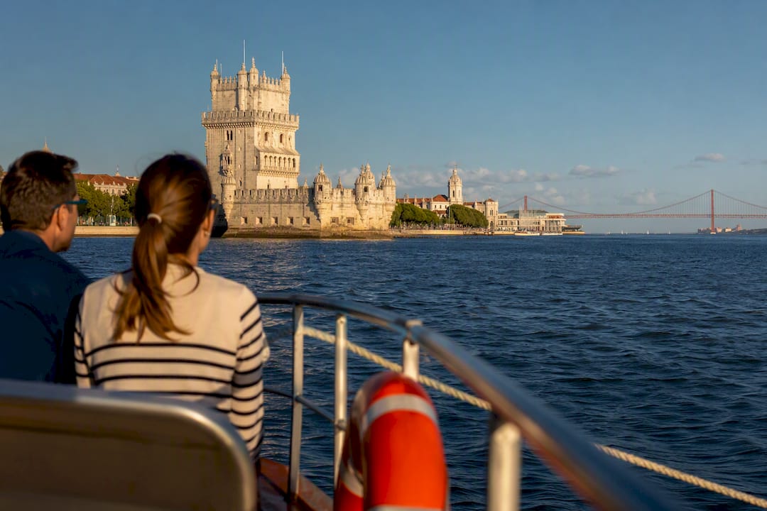 Passengers viewing Lisbon coastline from boat