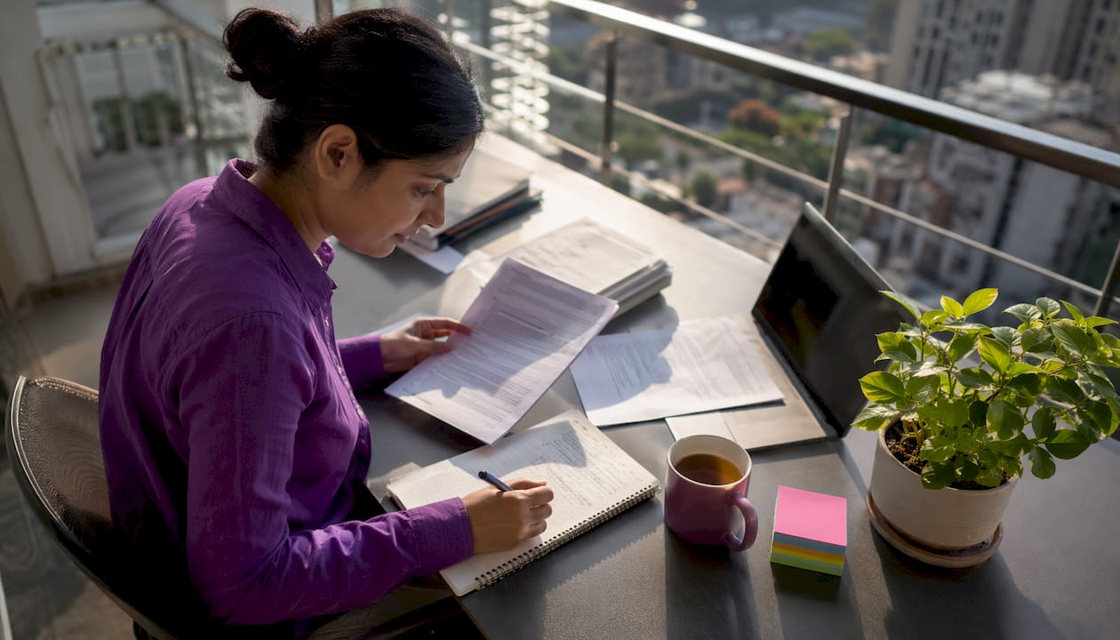 Researcher reviewing papers at office desk