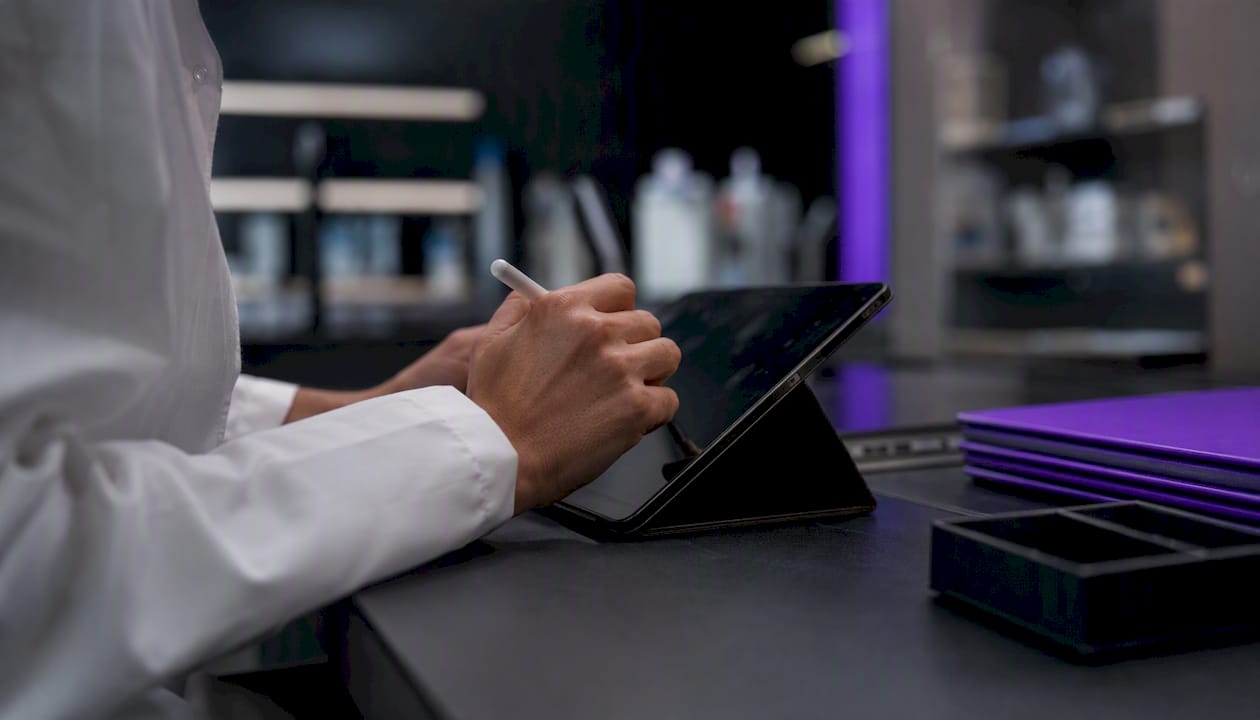 Hands updating digital audit trail on tablet