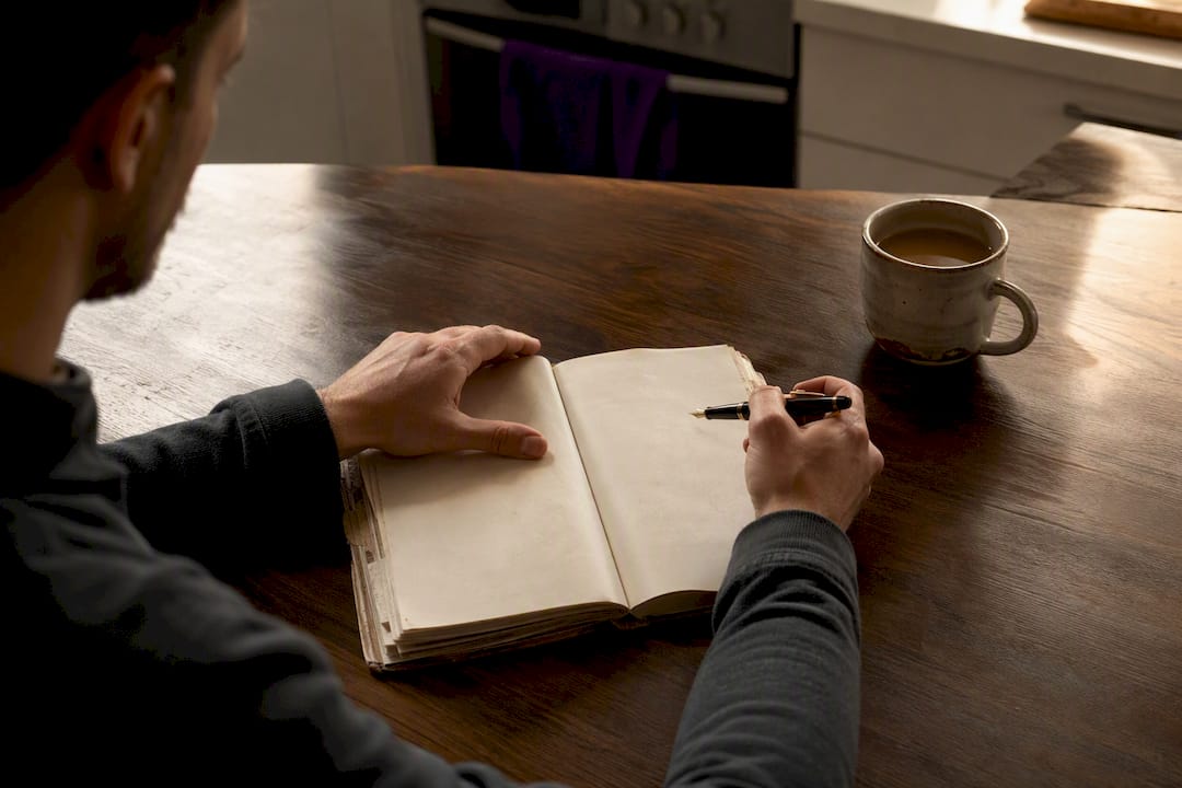 Researcher writing ambiguity log in notebook