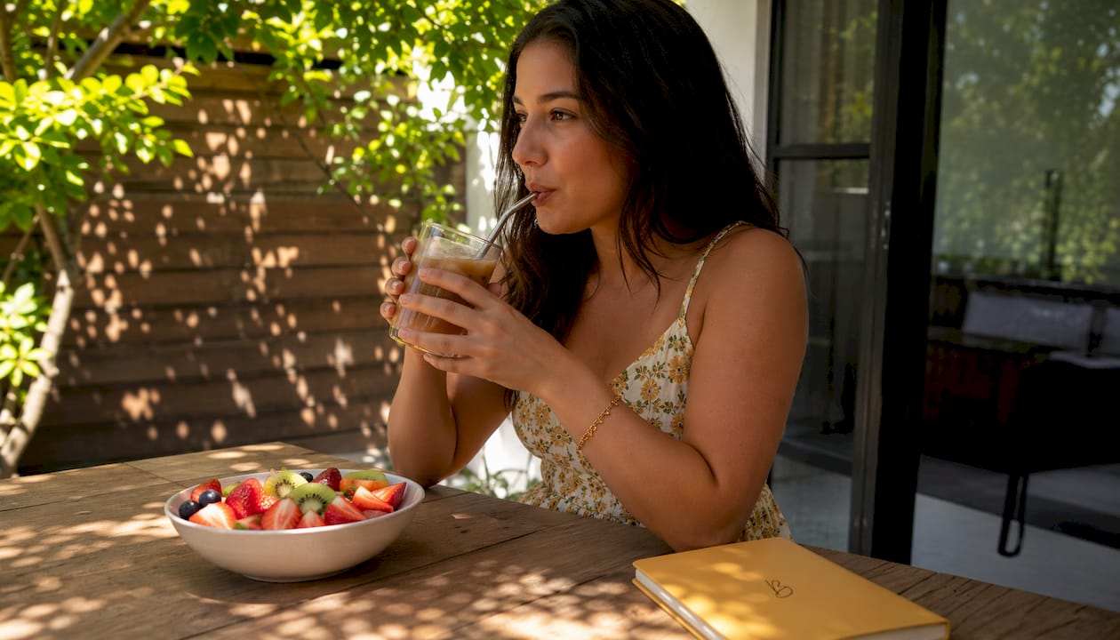 Hand drinking iced coffee through straw