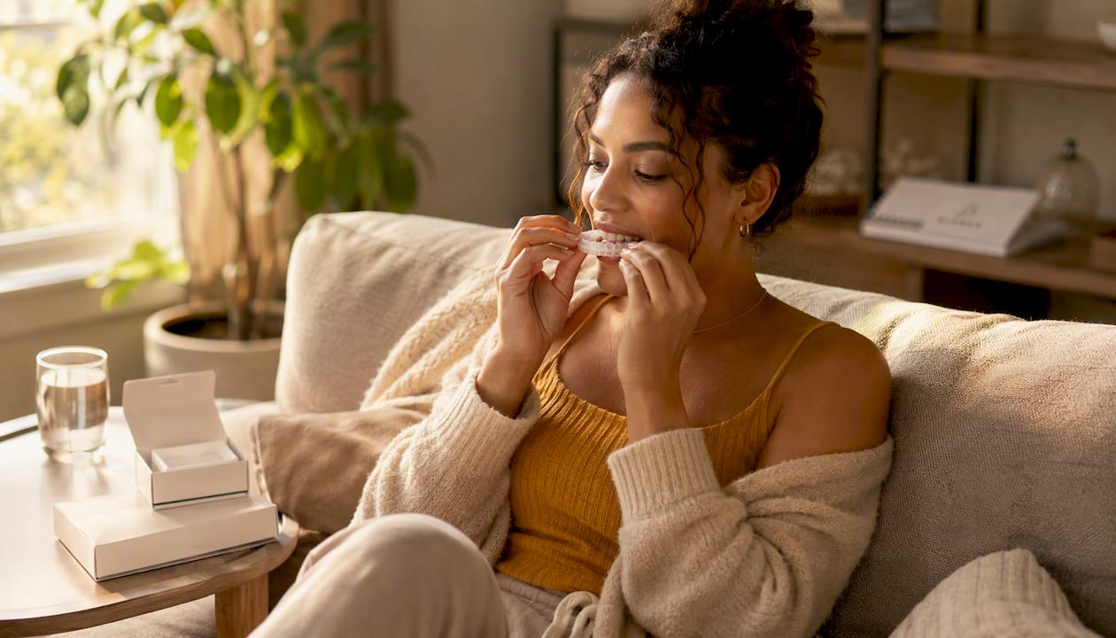 Woman using home whitening tray in bathroom