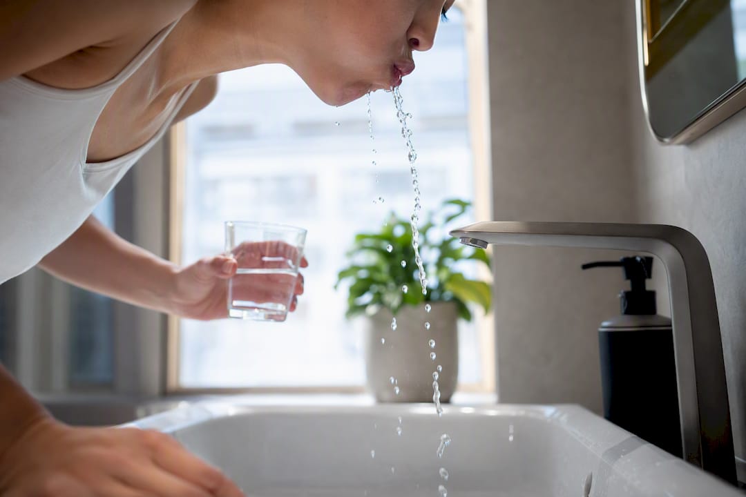 Person rinsing mouth after whitening strips