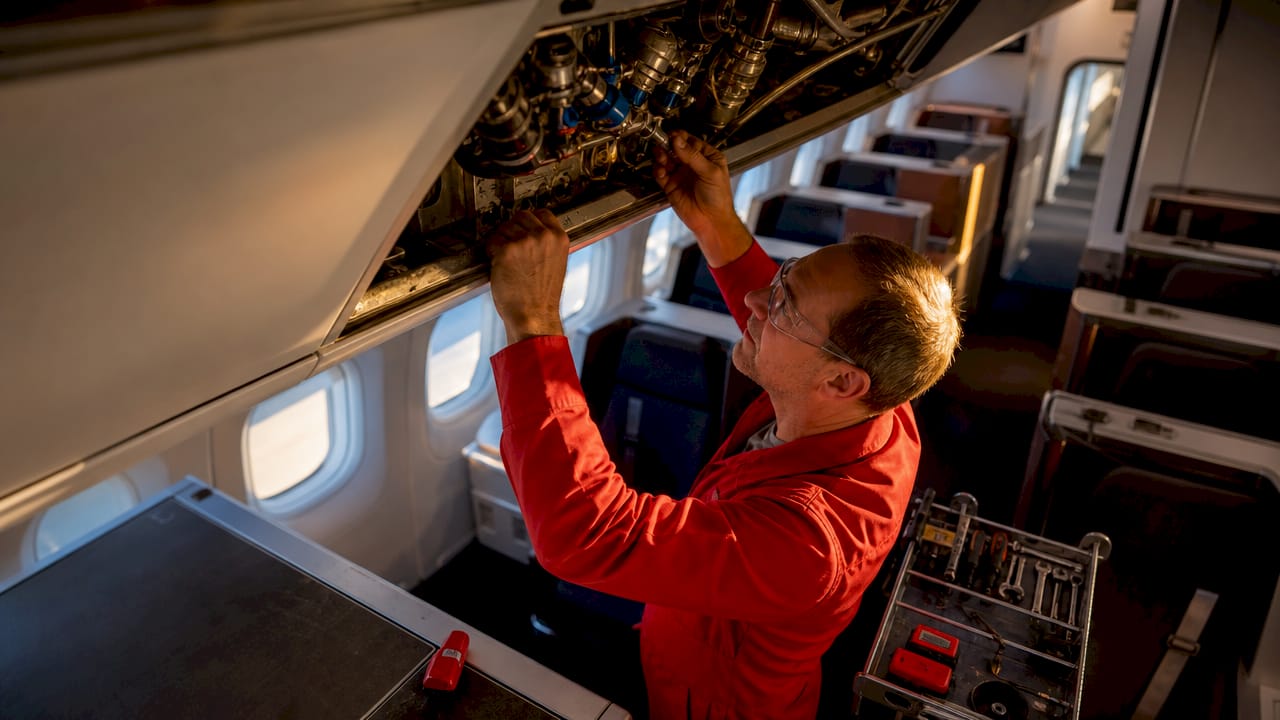 Technician inspecting airplane ventilation ducts