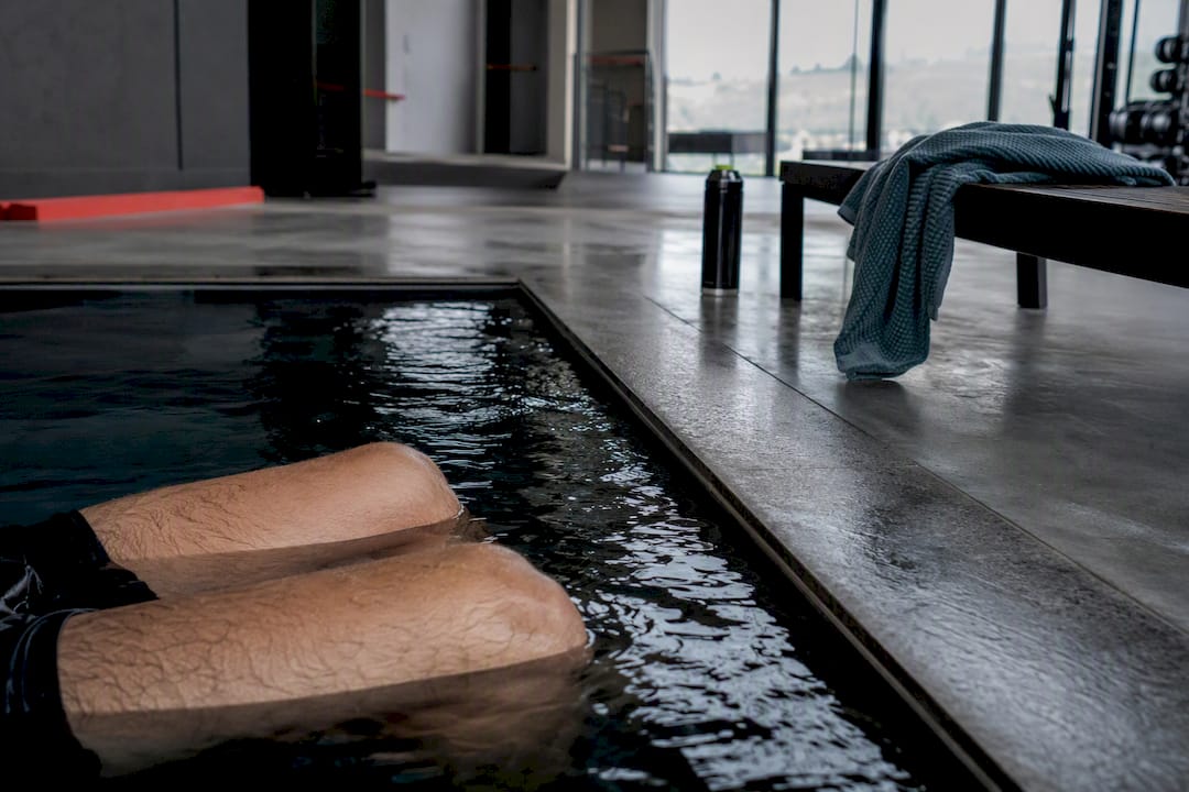 Athlete legs in cold water immersion pool