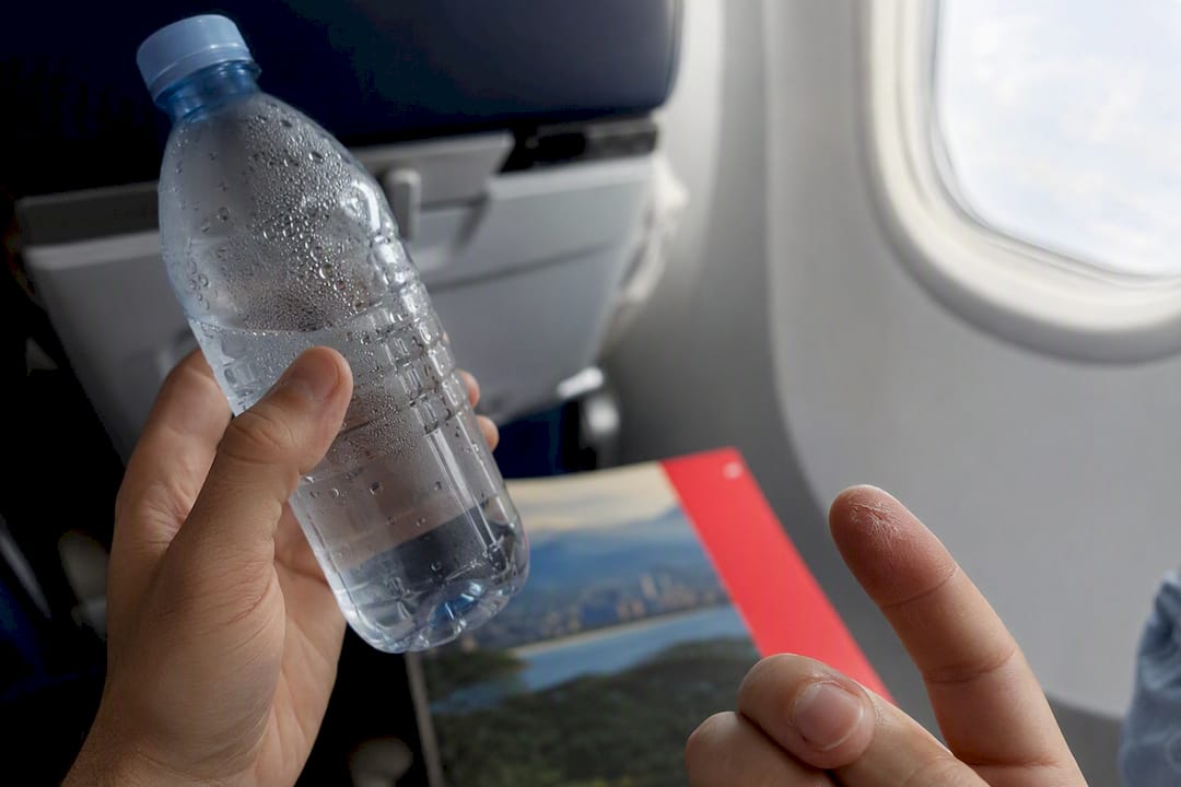 Pouring electrolyte powder into water bottle on plane
