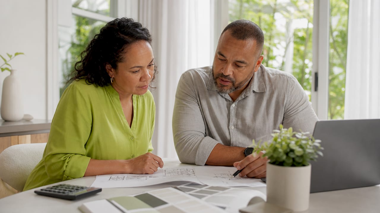 Couple planning family home renovation at kitchen table