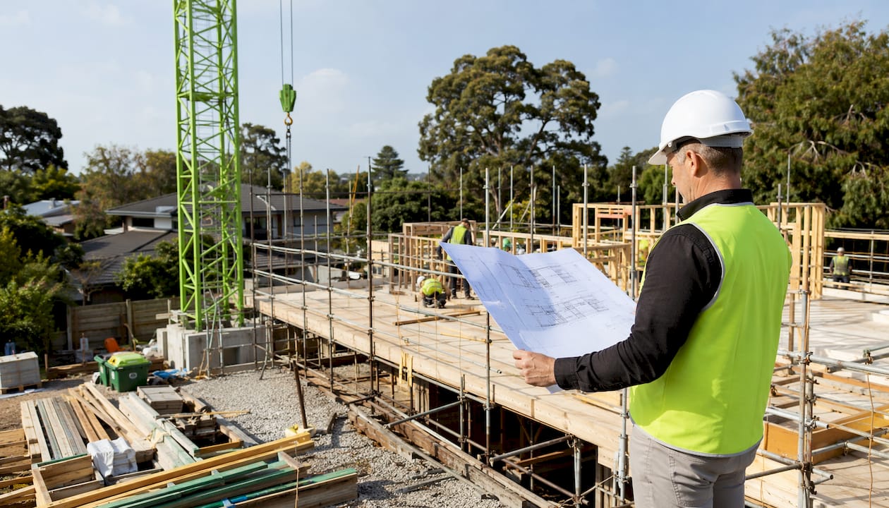 Construction manager reviewing blueprints on site