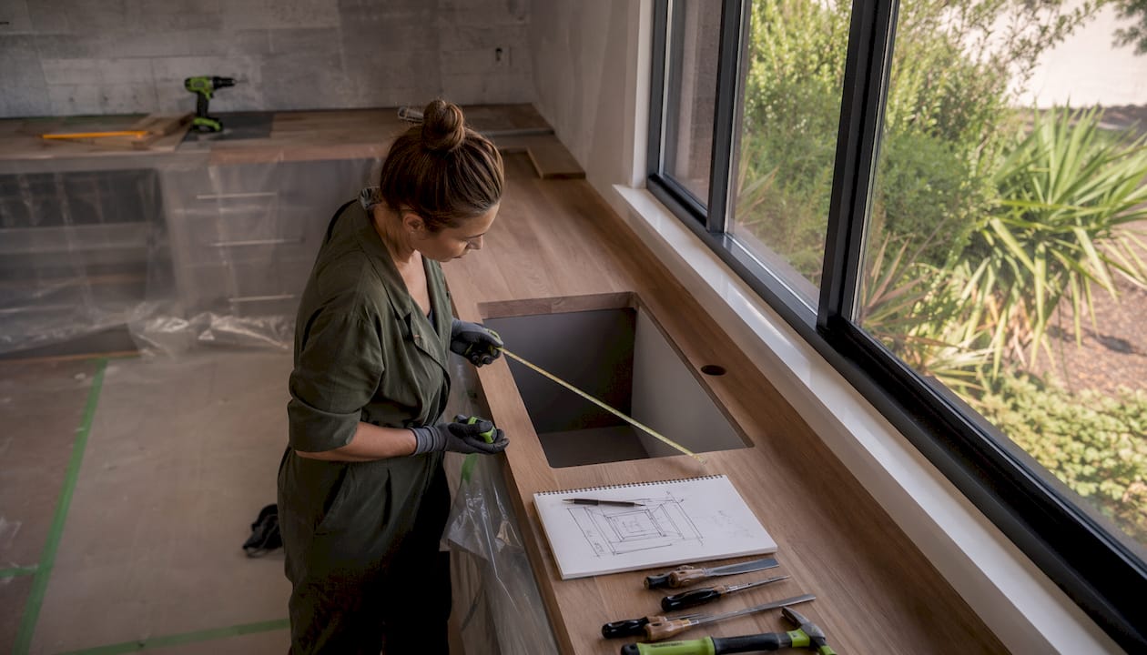 Contractor measuring in kitchen renovation space