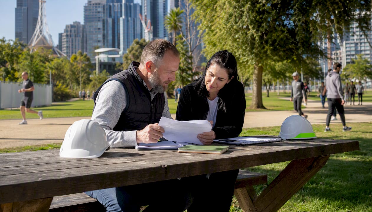 Builders reviewing contract quotes at outdoor cafe