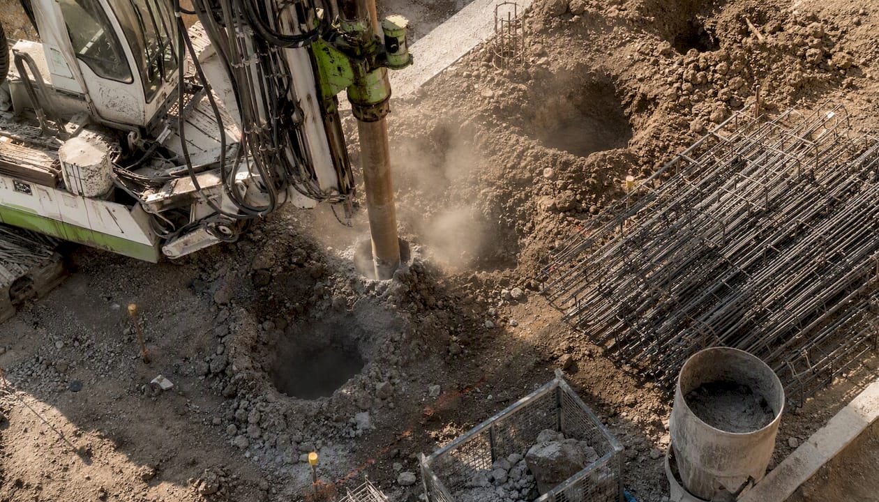 Drilling rig boring pier holes on site