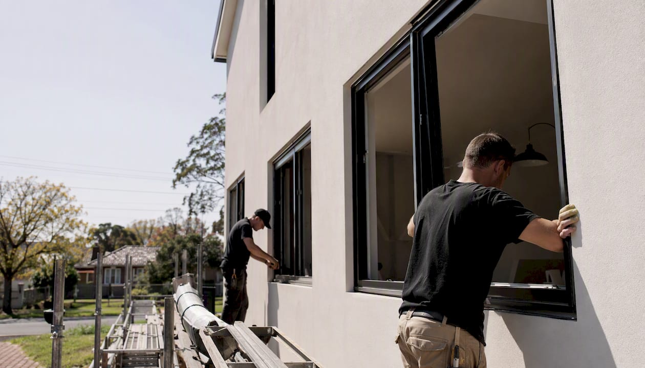 Builders installing new windows on suburban home