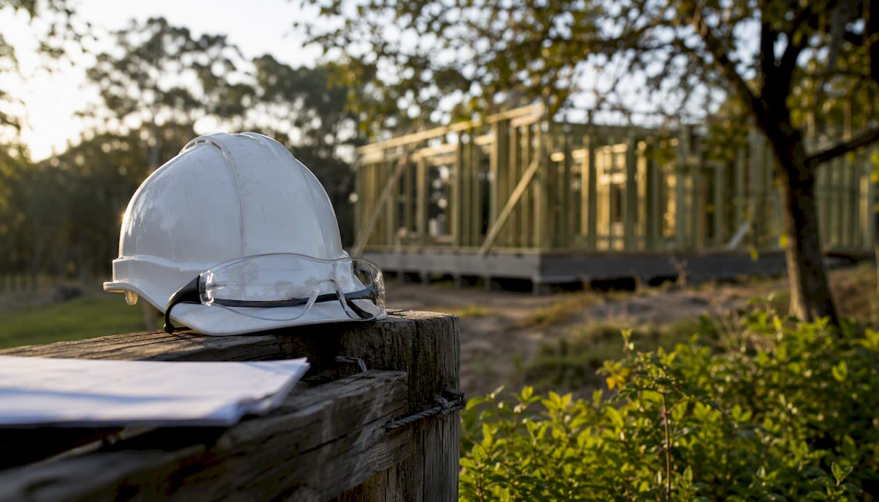 Hard hat resting on fence at construction site