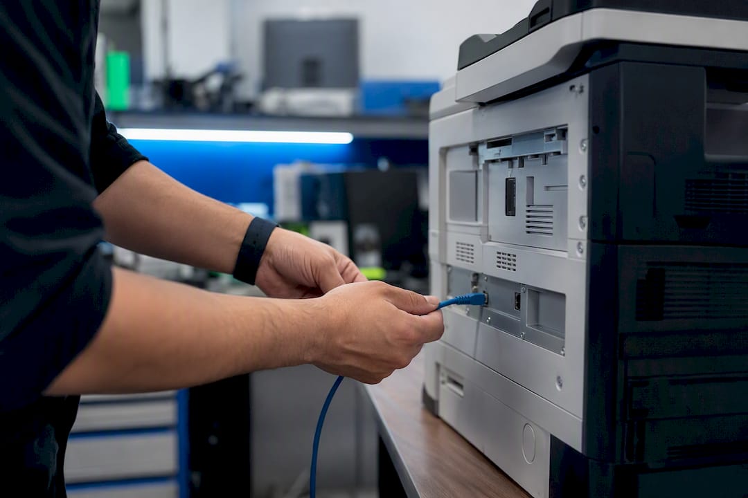Hands connecting printer network cable