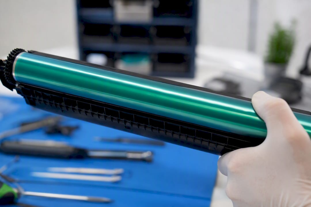 Close-up of laser printer drum unit held by technician