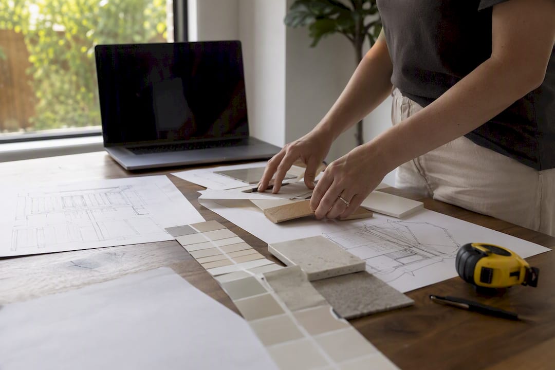 Hands arranging architectural plans and samples