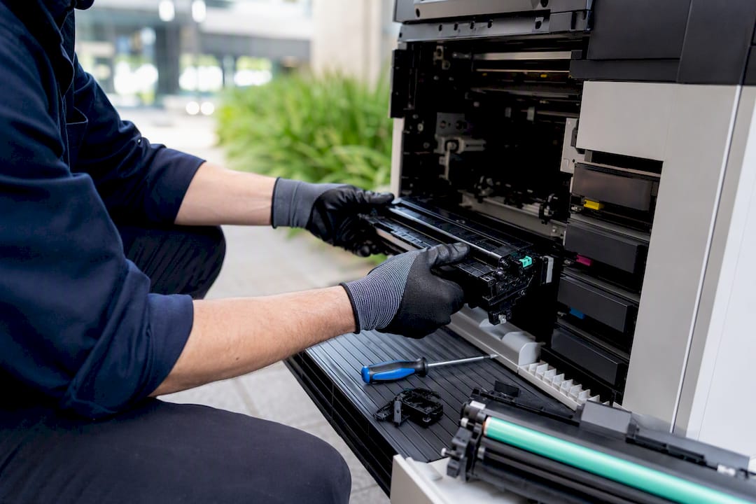 Technician hands repairing a printer component