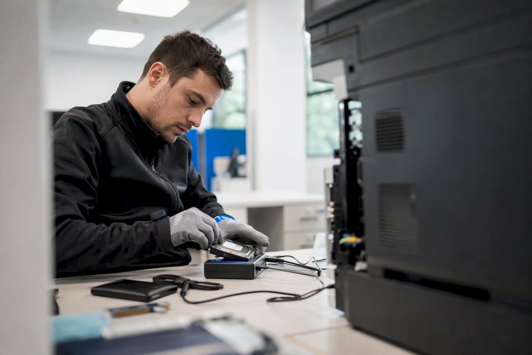 Gloved hands erasing printer hard drive securely