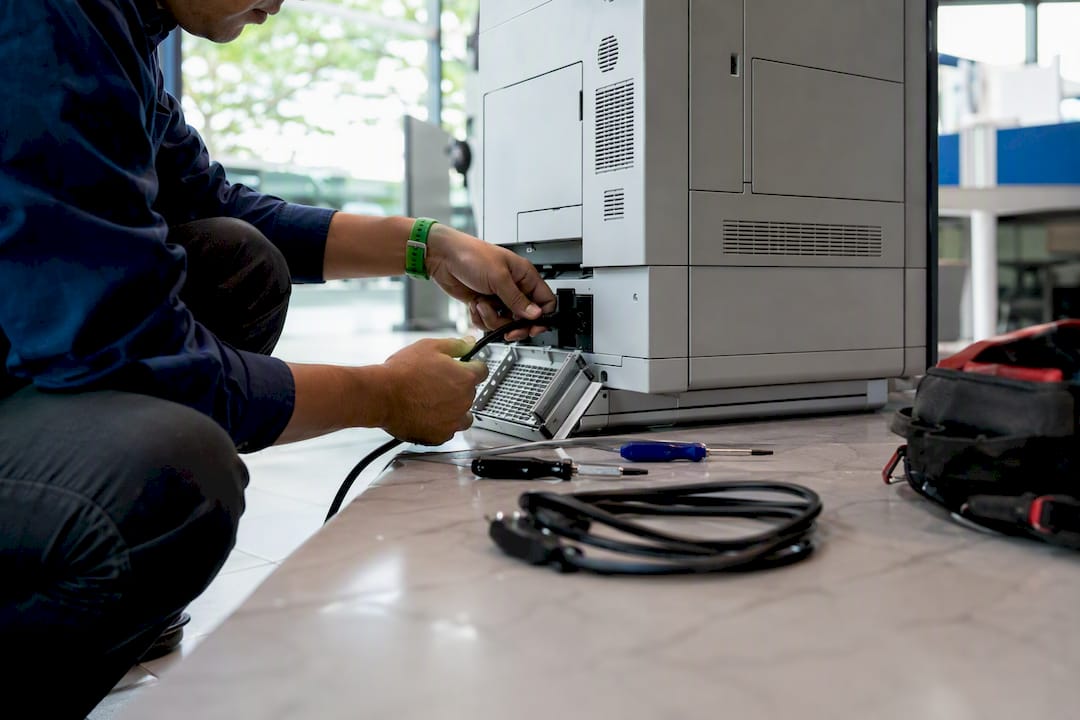 Technician disconnecting printer power cord
