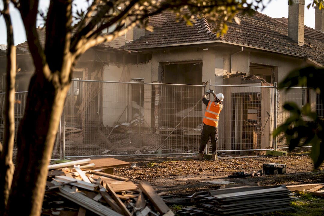 Worker setting up demolition barriers