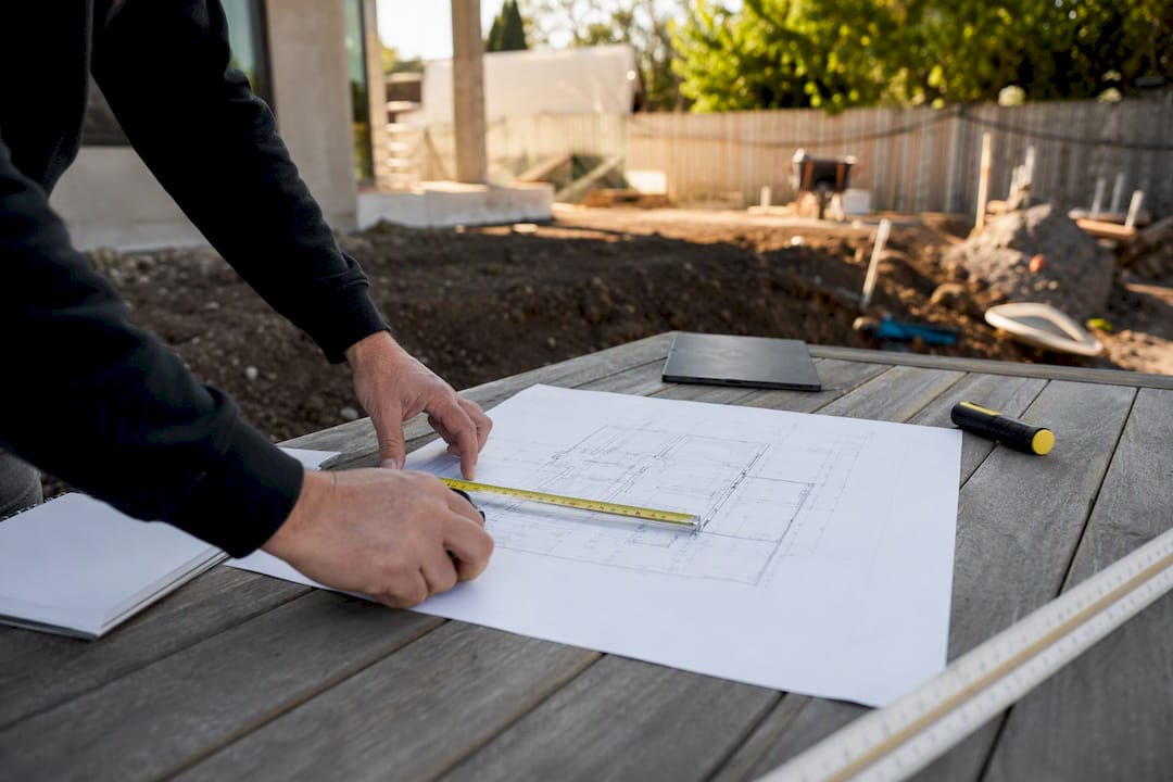 Architect's design plans and measuring tape on site