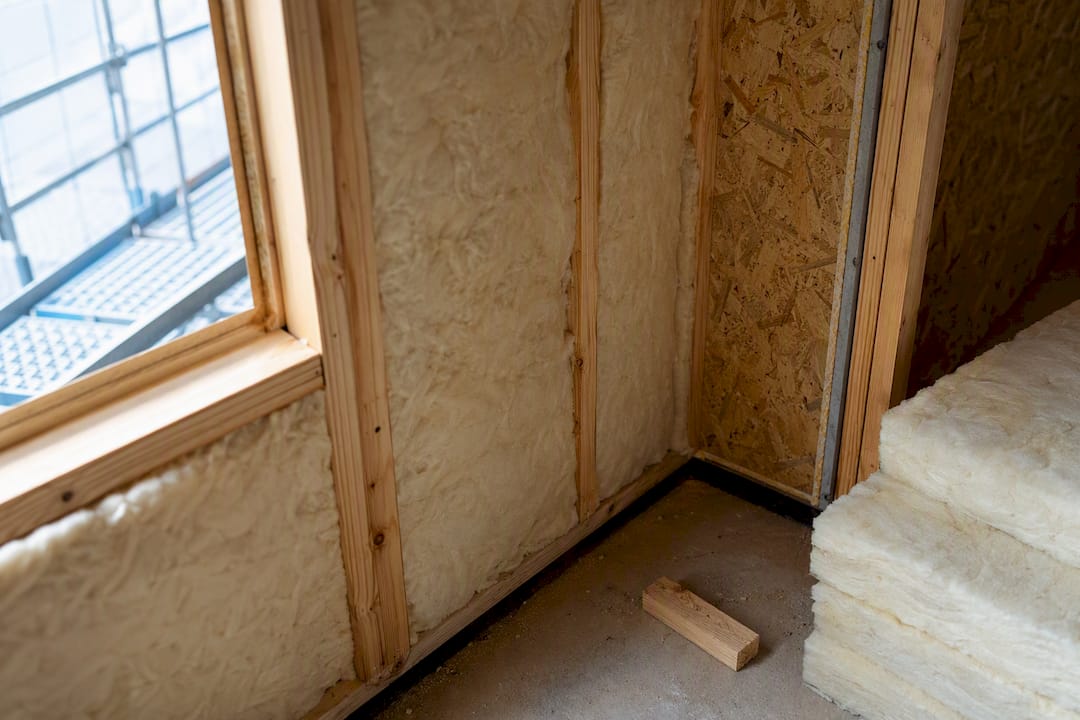 Insulation batts beside structural insulated panel