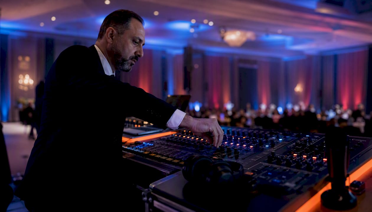 DJ adjusting wireless mic volume at gala