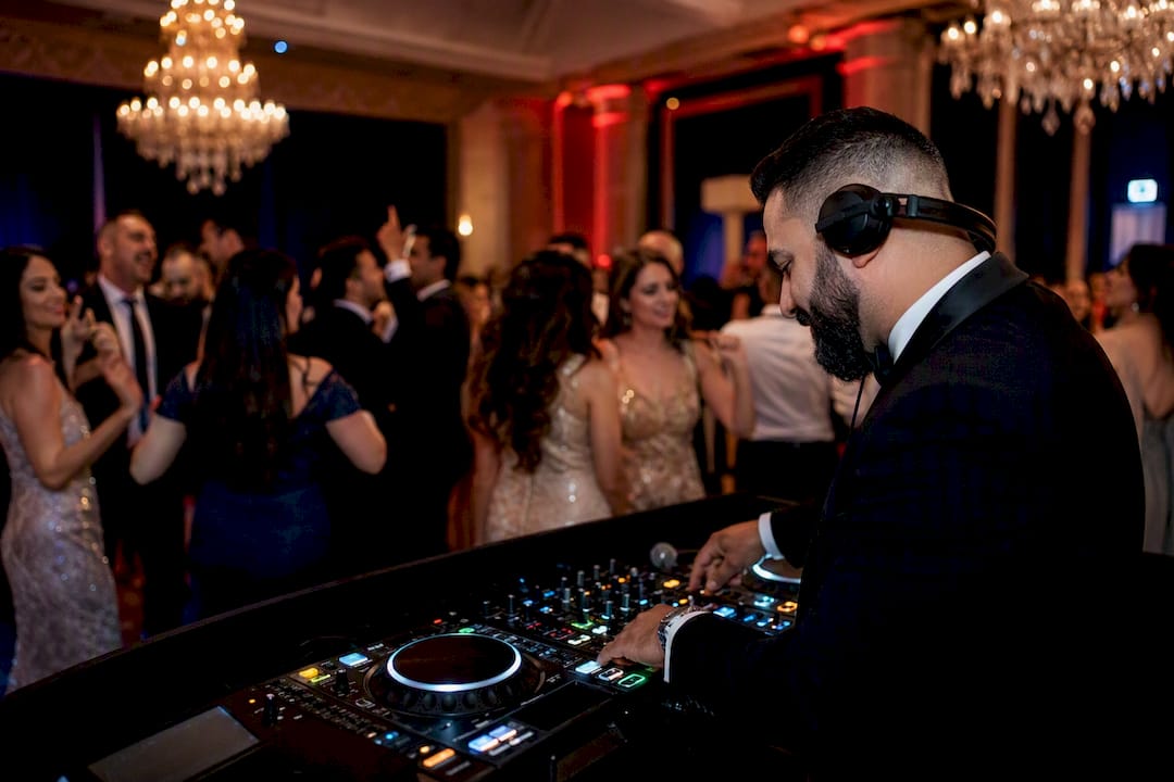 Wedding DJ mixing music at lively reception