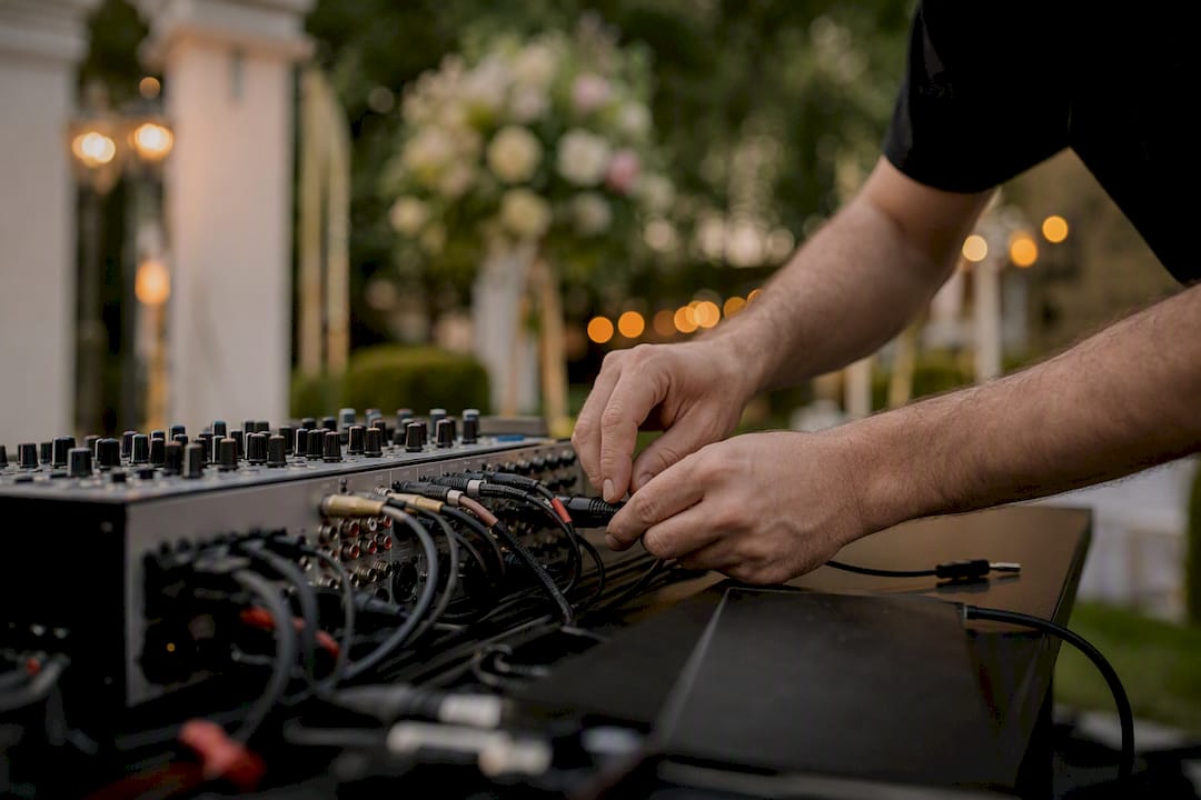 DJ hands connecting audio cables to mixer