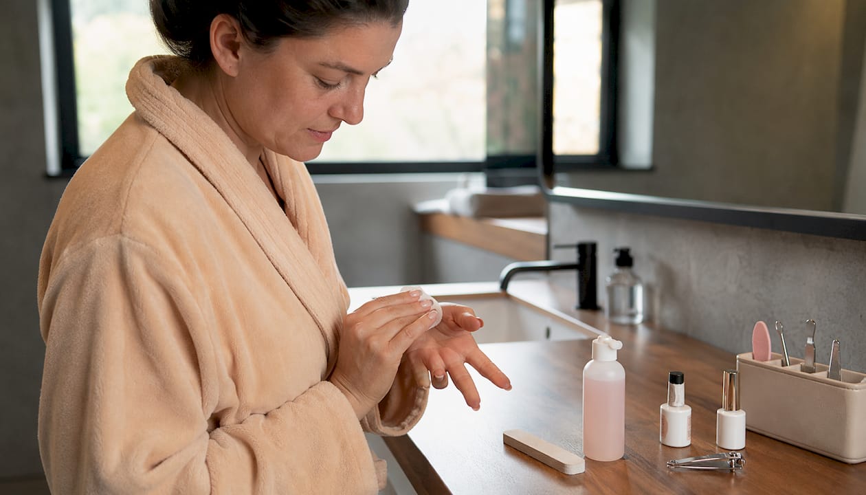 Vrouw verzorgt haar French gellak nagels zorgvuldig