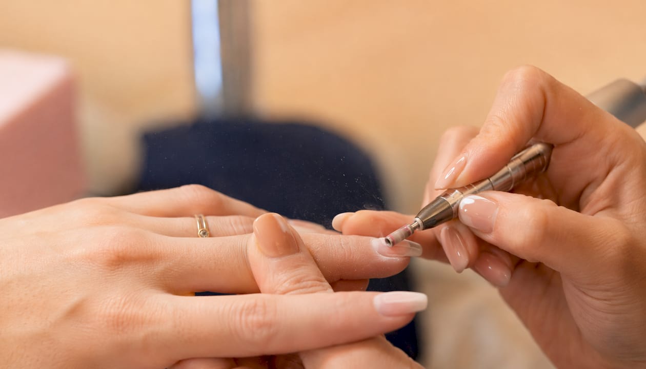Detailopname van een elektrische nagelfrees die wordt gebruikt op een BIAB-manicure
