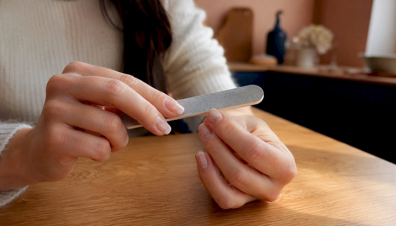 Een dikke laag builder gel handmatig vijlen met een grove nagelvijl