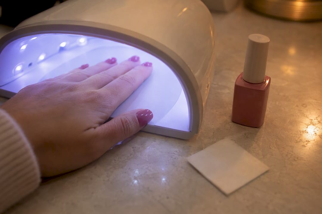 Hand die gellak uithardt onder UV-lamp