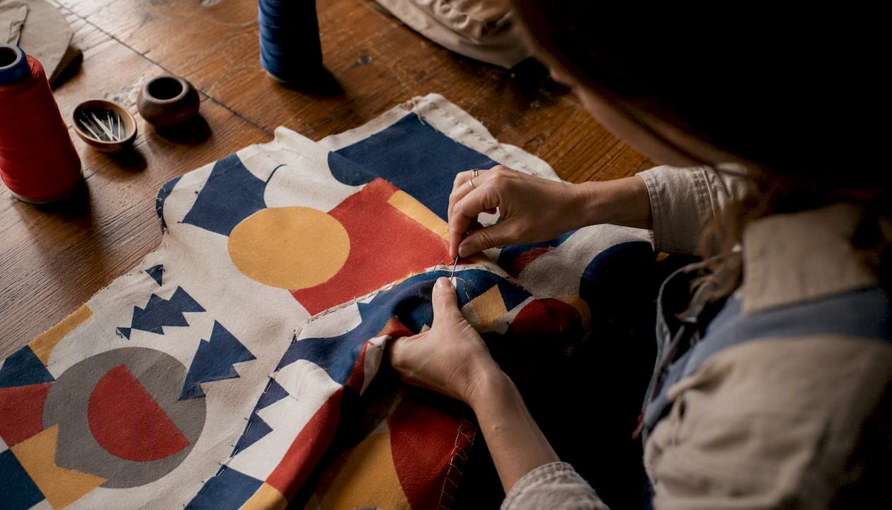 Hands sewing vintage-inspired apparel fabric