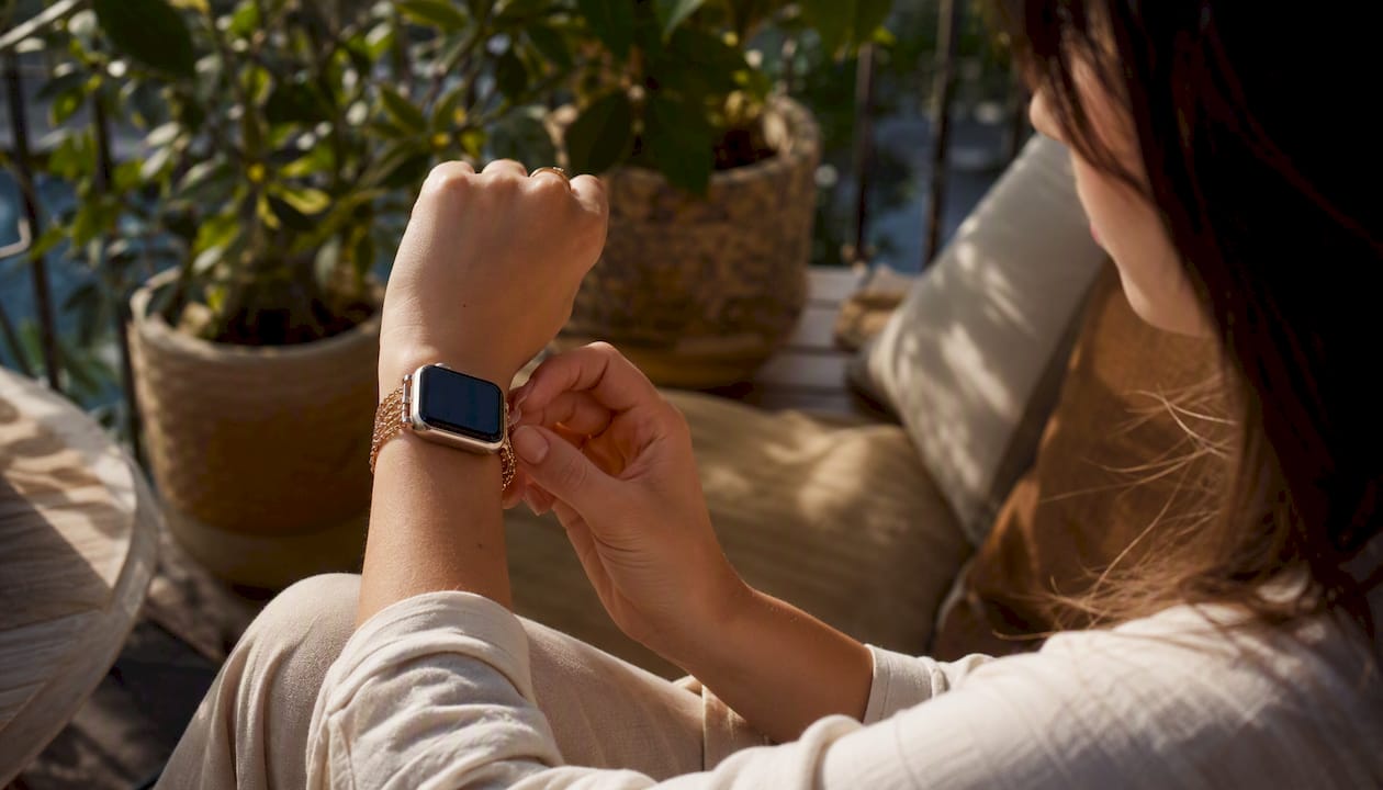 Woman adjusting jewelry-style watch band outdoors