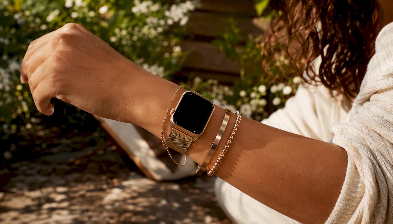 Wrist with yellow and rose gold jewelry in warm light